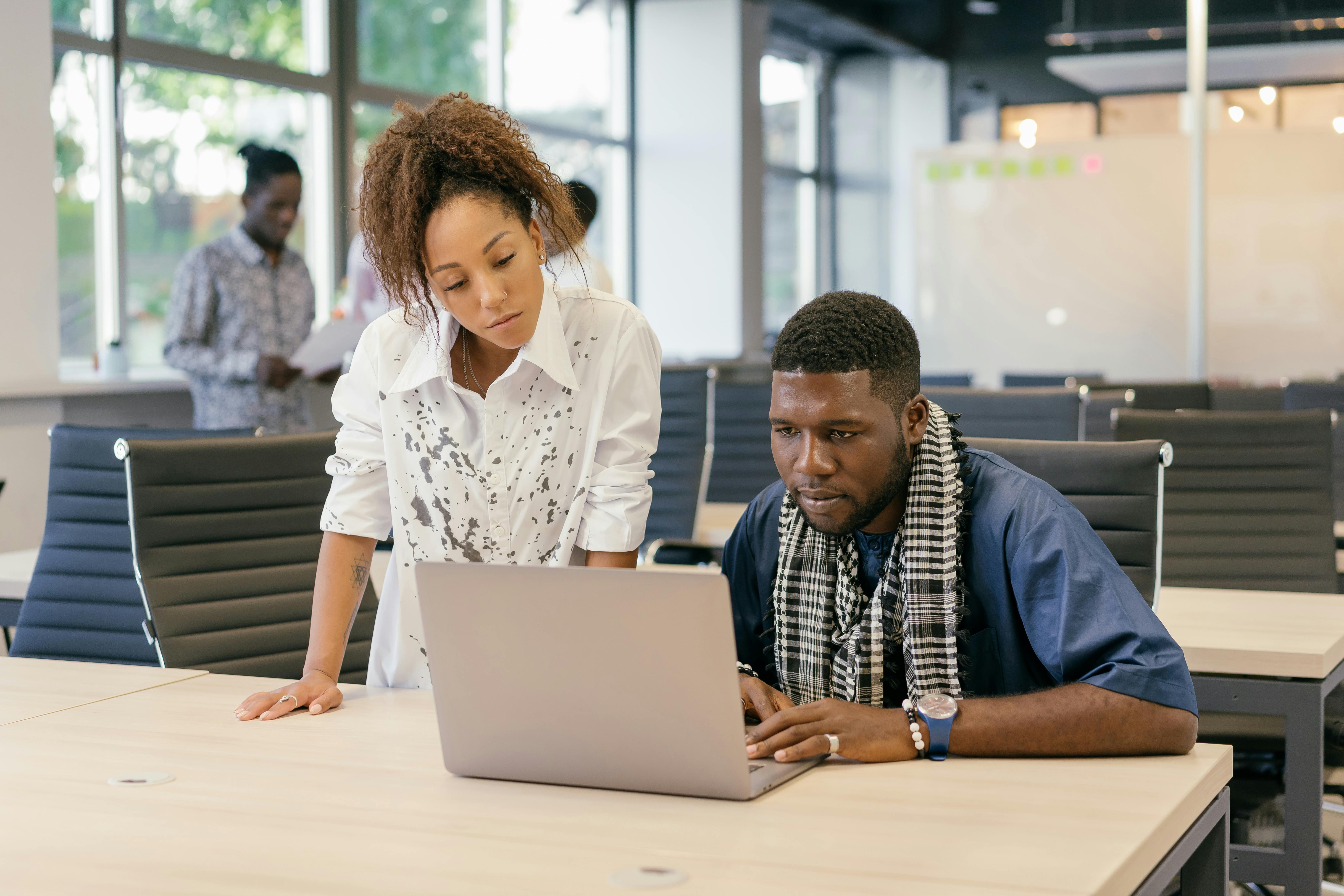 Team collaborating around a laptop in an office